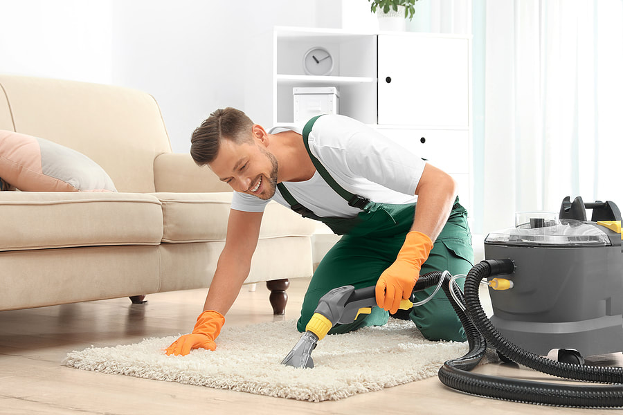 worker using a vacuum in the rug