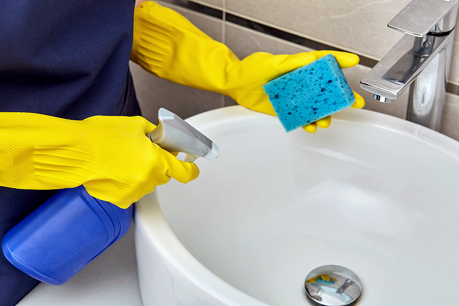 worker in gloves cleaning the sink